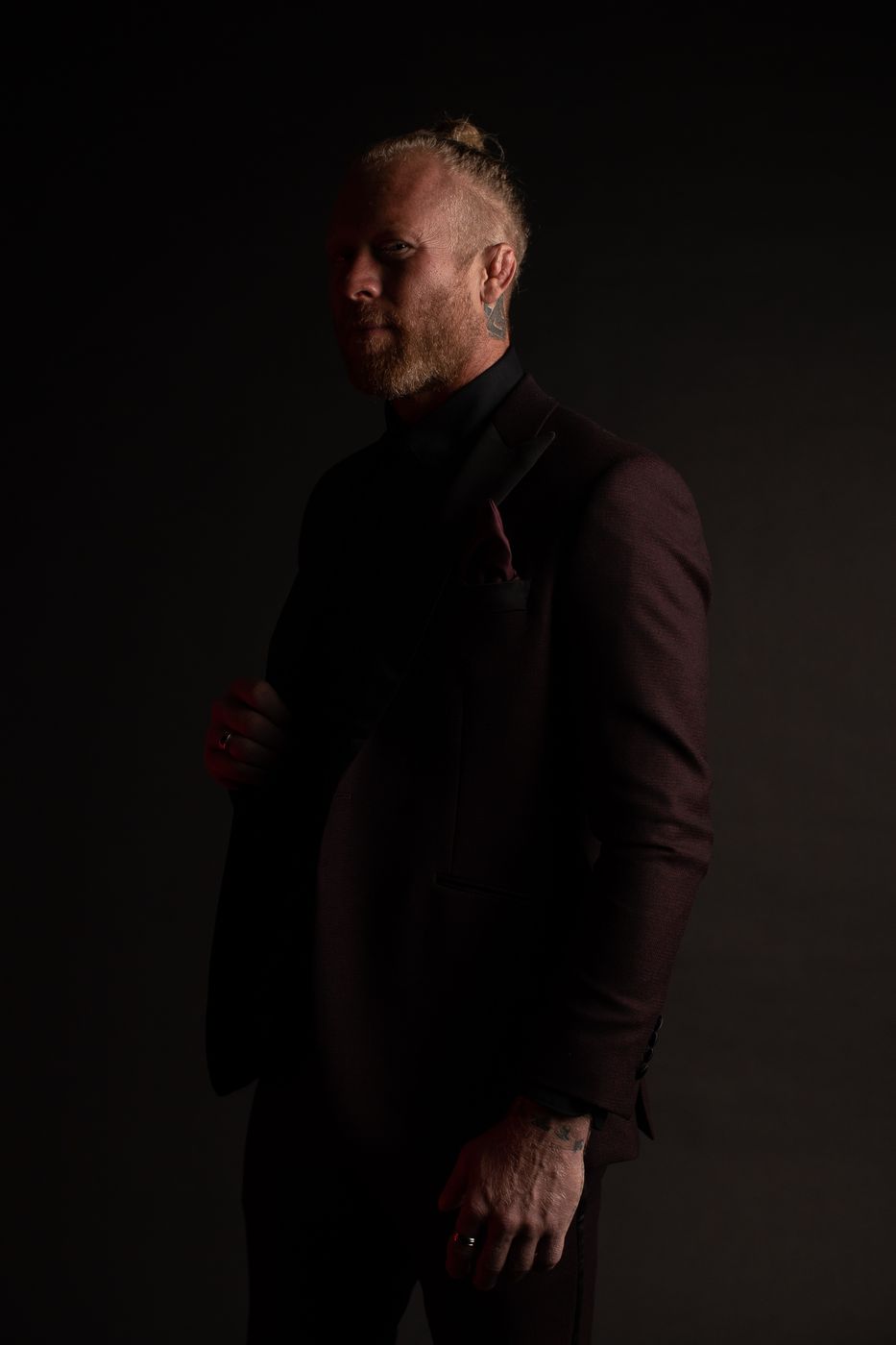 Portrait of Nathan Waits in a dark suit against a black background